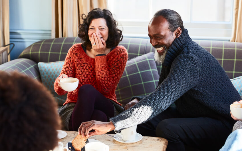 People sitting on a couch laughing and enjoying the company of others | Feature image for the Anxiety Hypnotherapy Melbourne page on Hypnofit.